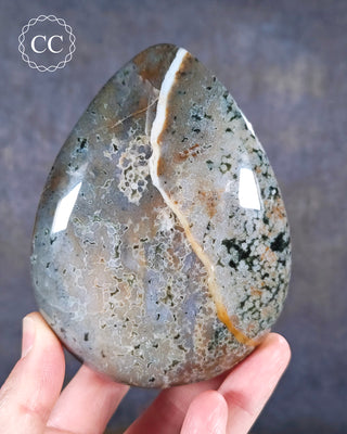 A hand holding an Ocean Jasper Freeform from Madagascar