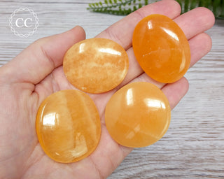 Orange Calcite Palm Stones in hand