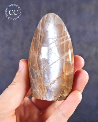 A hand holding a Peach Moonstone Freeform from Madagascar