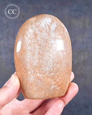 A hand holding a Peach Moonstone Freeform from Madagascar