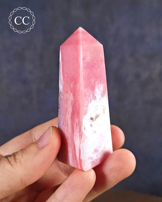 A hand holding a Pink Andean Opal Tower from Peru