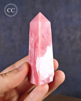 A hand holding a Pink Andean Opal Tower from Peru