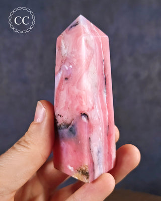 A hand holding a Pink Andean Opal Tower from Peru