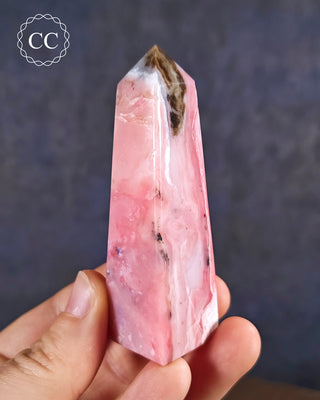 A hand holding a Pink Andean Opal Tower from Peru