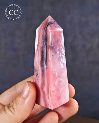 A hand holding a Pink Andean Opal Tower from Peru