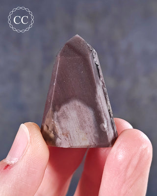 A hand holding a Pink Phantom Quartz Tower from Brazil 