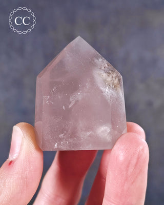 A hand holding a Pink Phantom Quartz Tower from Brazil 