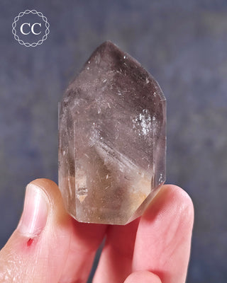 A hand holding a Pink Phantom Quartz Tower from Brazil 