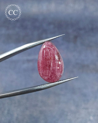 Gemstone tweezers holding a Pink Tourmaline Cabochon from Siberia 