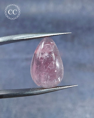 Gemstone tweezers holding a Pink Tourmaline Cabochon from Siberia 