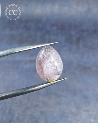 Gemstone tweezers holding a Pink Tourmaline Cabochon from Siberia 