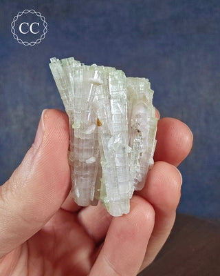 A hand holding a Pink and Green tipped Tourmaline cluster from Afghanistan 