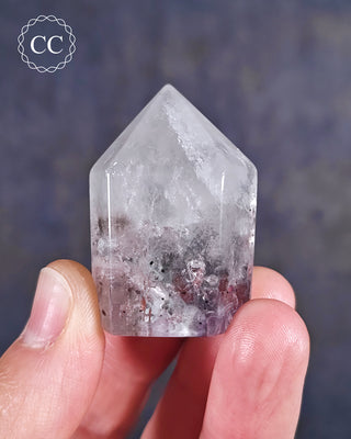 Fingers holding a polished Brandberg Amethyst Tower from Namibia