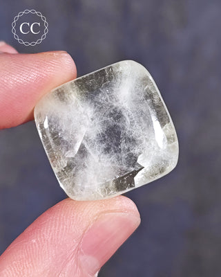 A hand holding a polished Green Apophyllite crystal