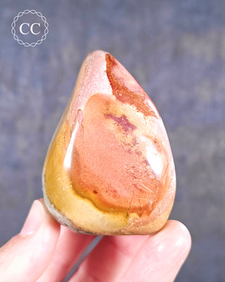 A hand holding a Polychrome Jasper freeform from Madagascar