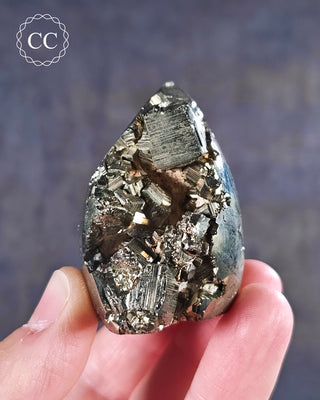 A hand holding a part polished Pyrite Freeform from Peru