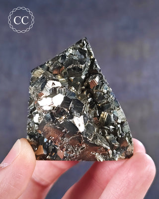 A hand holding a part polished Pyrite Freeform from Peru