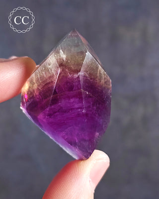 A hand holding a Rainbow Fluorite Freeform 