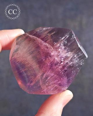 A hand holding a Rainbow Fluorite Freeform 