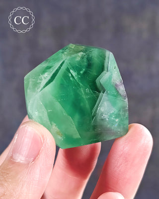 A hand holding a Rainbow Fluorite Freeform 