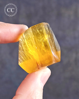 A hand holding a Rainbow Fluorite Freeform 