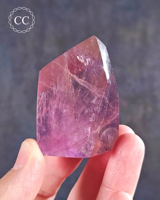 A hand holding a Rainbow Fluorite Freeform 