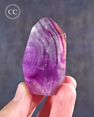 A hand holding a Rainbow Fluorite Freeform 