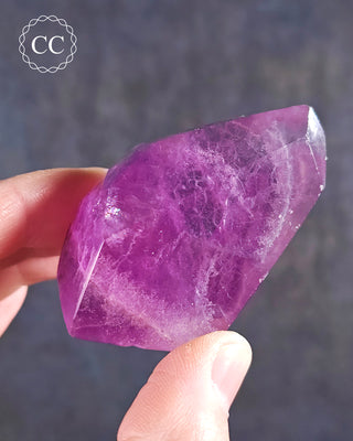 A hand holding a Rainbow Fluorite Freeform 