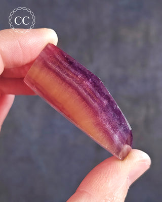 A hand holding a Rainbow Fluorite Freeform 