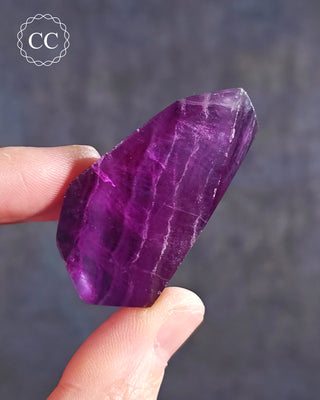 A hand holding a Rainbow Fluorite Freeform 