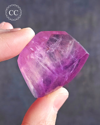 A hand holding a Rainbow Fluorite Freeform 