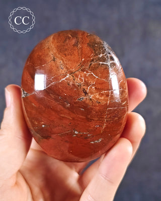 A hand holding a Red Jasper Chunky Palmstone from Madagascar