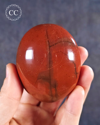 A hand holding a Red Jasper Chunky Palmstone from Madagascar
