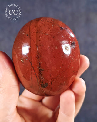 A hand holding a Red Jasper Chunky Palmstone from Madagascar