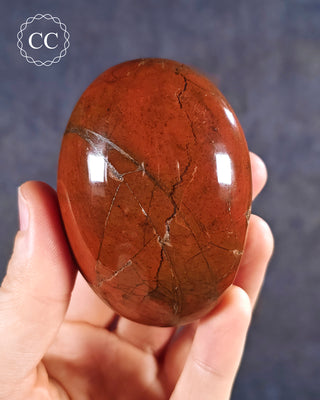 A hand holding a Red Jasper Chunky Palmstone from Madagascar