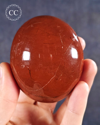 A hand holding a Red Jasper Chunky Palmstone from Madagascar