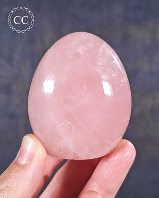 A hand holding a Rose Quartz freeform from Madagascar