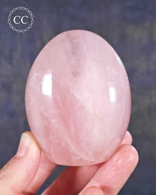 A hand holding a Rose Quartz freeform from Madagascar