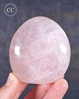 A hand holding a Rose Quartz freeform from Madagascar