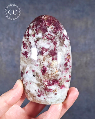 A hand holding a Rubellite - Pink Tourmaline freeform from Madagascar