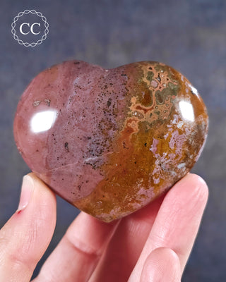 A hand holding a Sea Jasper Heart from Madagascar