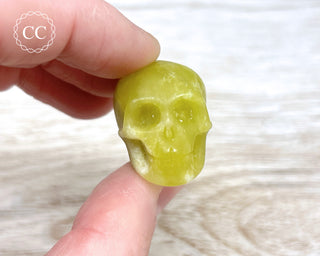 Fingers holding a Serpentine Crystal skull 