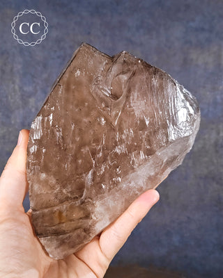 A hand holding a large Smoky Elestial Quartz from Brazil