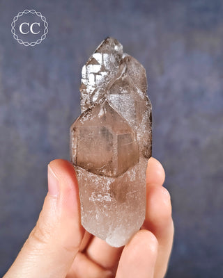 A hand holding an Smoky Elestial Quartz from Brazil