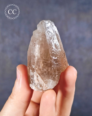 A hand holding an Smoky Elestial Quartz from Brazil