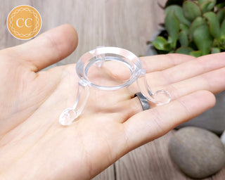 Clear plastic sphere stand in hand